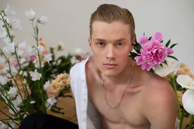 Sensitive man posing with flowers front view