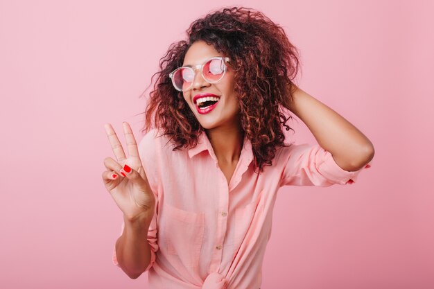 Sensual african lady in trendy vintage outfit enjoying good day. Fascinating lovable woman in sunglasses chilling.