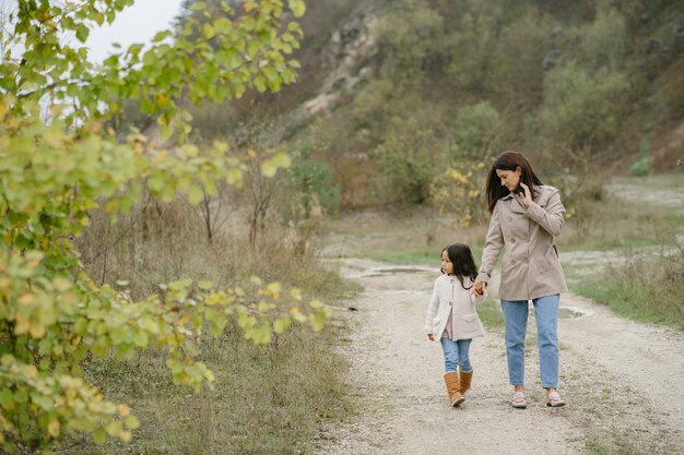 Sensual photo. Cute little girl. People walks outside. Woman in a brown coat.