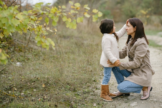 Sensual photo. Cute little girl. People walks outside. Woman in a brown coat.