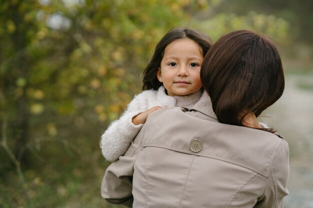 Sensual photo. Cute little girl. People walks outside. Woman in a brown coat.