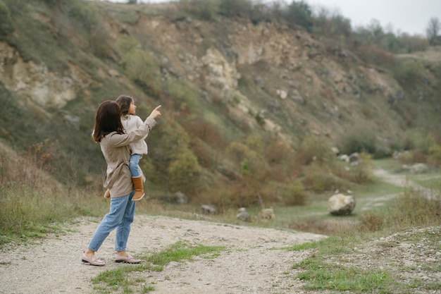 Sensual photo. Cute little girl. People walks outside. Woman in a brown coat.