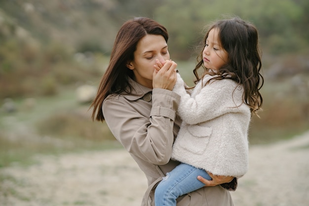 Sensual photo. Cute little girl. People walks outside. Woman in a brown coat.