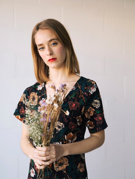 Sensual sad woman with bouquet of dry plants