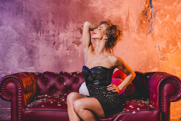 Sensual woman on couch with confetti