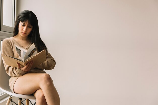 Sensual woman reading on chair