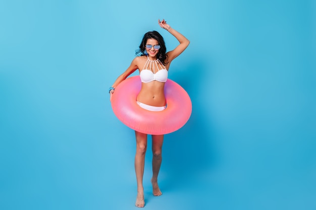 Sensual woman in sunglasses posing with swimming circle