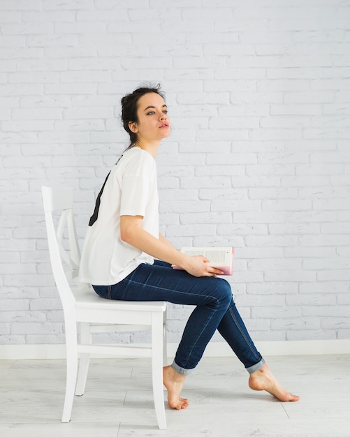 Sensual woman with book on chair