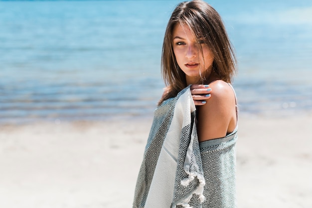 Free photo sensual woman wrapping in scarf on beach