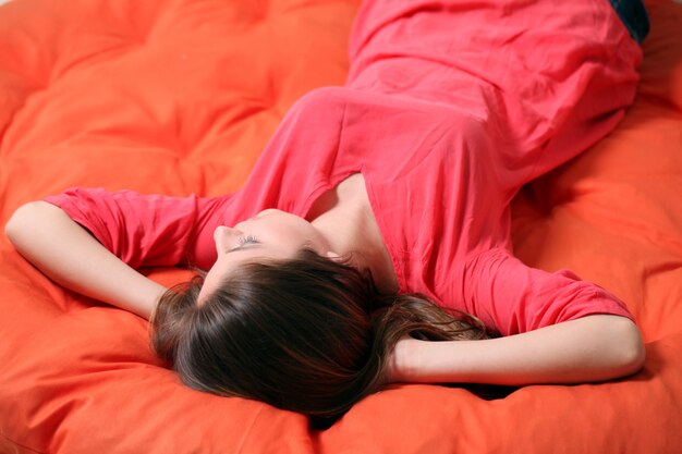 Чувственная молодая женщина мечтает на одеяле
