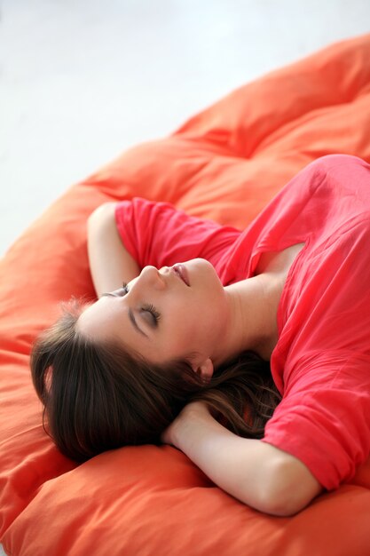 Чувственная молодая женщина мечтает на одеяле