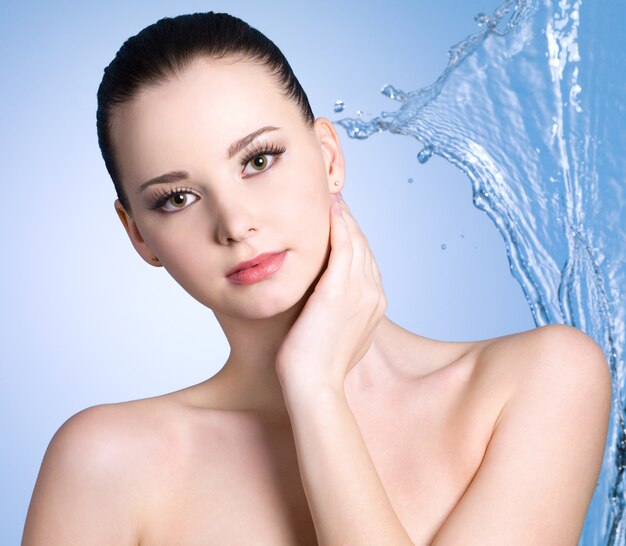 Sensuality young woman with stream of water - blue background