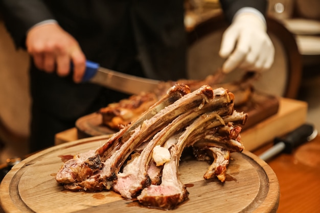 Separated grilled ribs on the wooden board side view