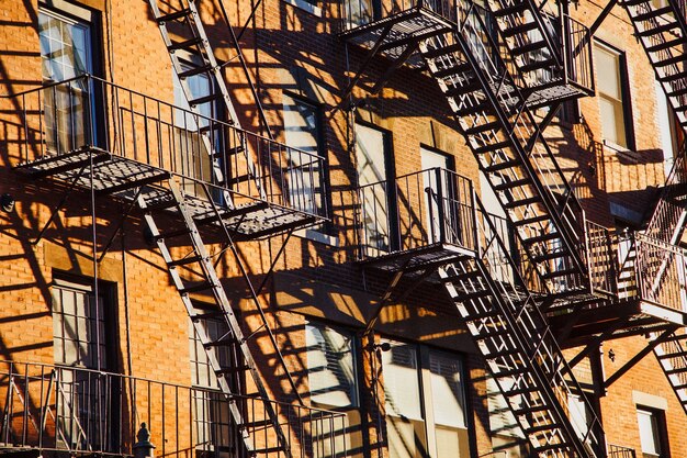 Серия пожарных лестниц на фасаде многоквартирного кирпичного дома в городе