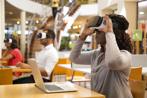 Serious African American woman wearing virtual reality glasses