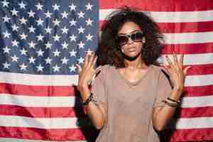 Free photo serious african young lady standing over usa flag