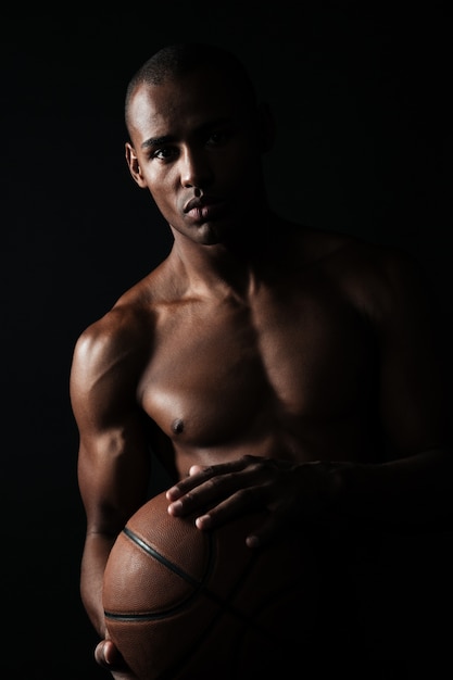 Free photo serious afroamerican basketball player holding ball,