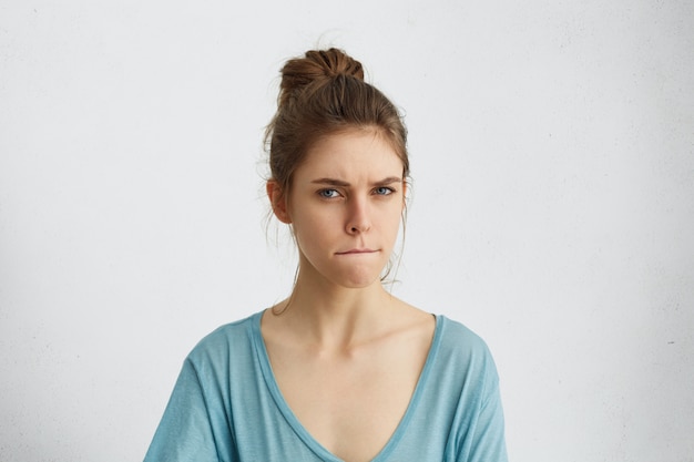 Free photo serious angry woman frowning her face pressing lips together with anger trying to control herself and her emotions not showing her annoyance and anger.