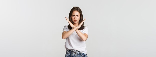 Foto gratuita una donna arrabbiata seria che mostra una croce ferma qualcosa di brutto esprime disapprovazione o antipatia