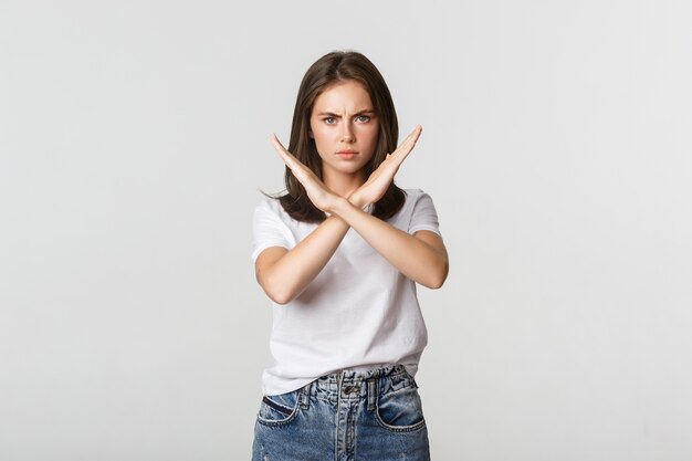 Serious angry woman showing cross, stop something bad, express disapproval or dislike.