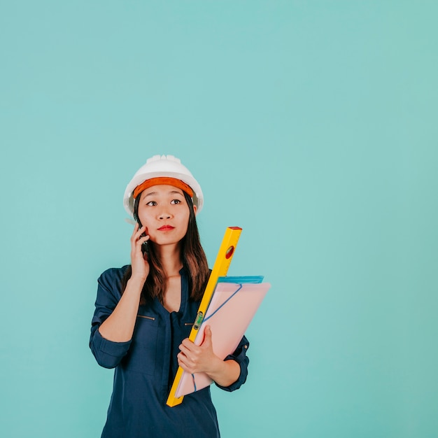 Foto gratuita draftswoman asiatico serio che parla sul telefono