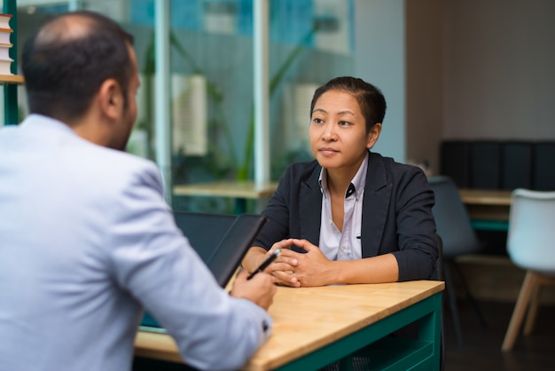 Free photo serious asian woman meeting with business partner