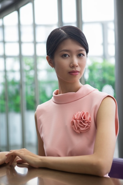 Free photo serious asian woman sitting at table in cafe