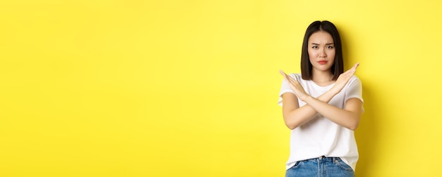 Free photo serious and assertive korean woman showing cross stop gesture frowning and telling no prohibit actio