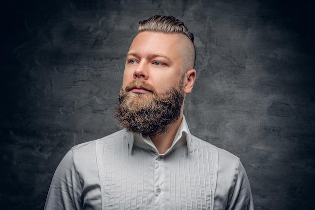 Serious bearded male in a white shirt on grey vignette background.