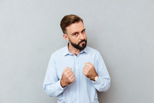 Serious bearded man in business clothes ready to fight