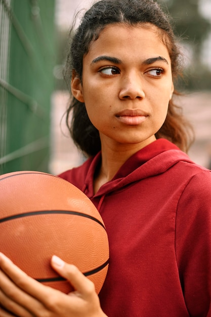 Серьезная темнокожая американская женщина играет в баскетбол