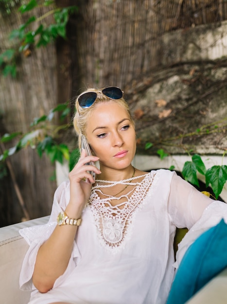 Серьезная блондинка молодая женщина, с помощью мобильного телефона