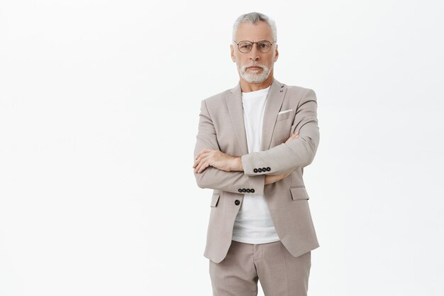 Serious bossy old businessman cross arms and looking confident