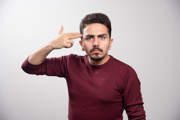 A serious brunette man posing with his hands .