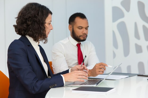 Serious business colleagues with computer and documents