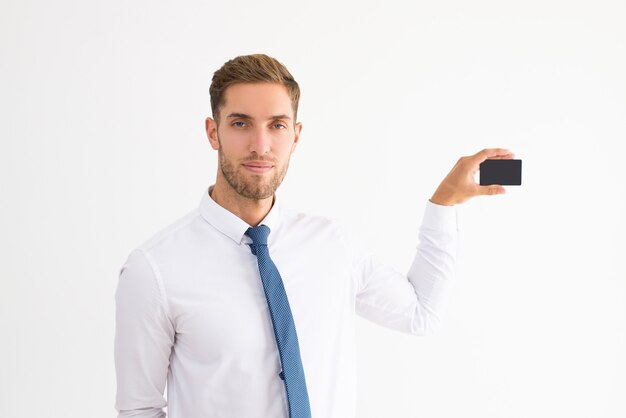 Free photo serious business man showing blank business card