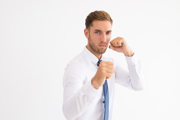 Serious business man standing in boxing pose