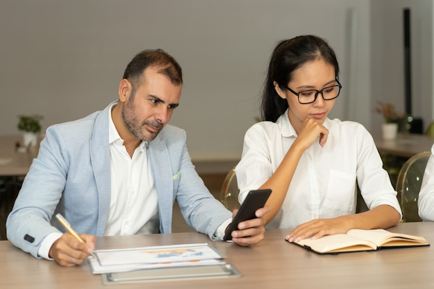 Serious business man and woman working at desk in office