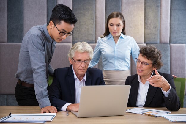 Serious business team watching laptop presentation