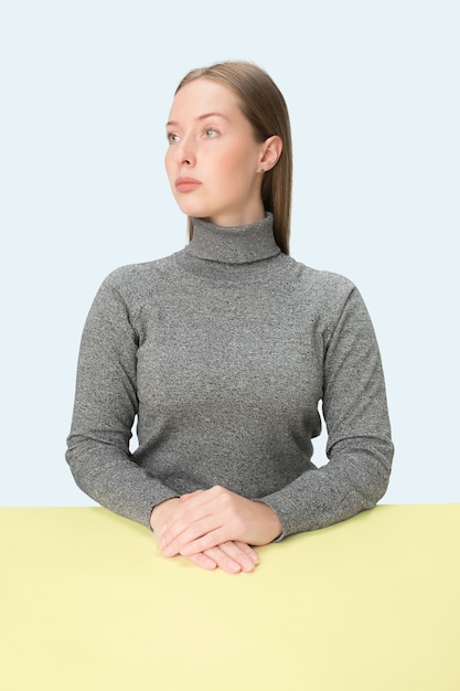 Serious business woman sitting at table  The portrait in minimalism style