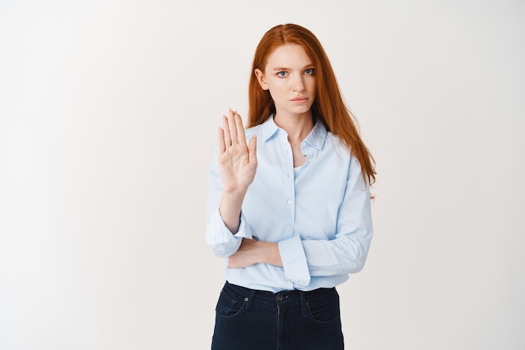 Free Photo serious business woman with red long hair telling to stop showing rejection sign and frowning disappointed dislke and disapprove something white background