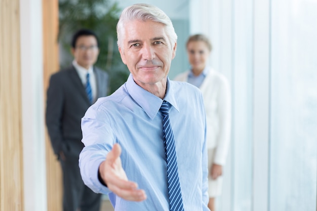 Serious businessman extending hand for handshake