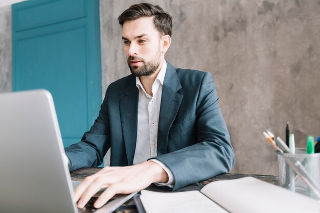 Serious businessman using laptop