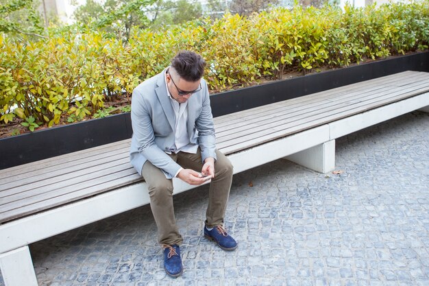 Serious Businessman Using Smartphone in Park