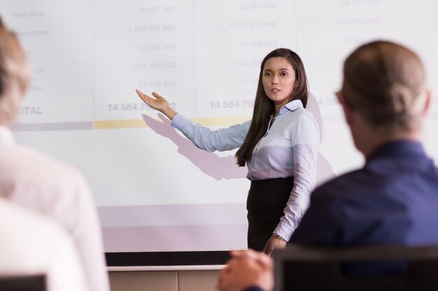 Serious Businesswoman Explaining Table to Audience