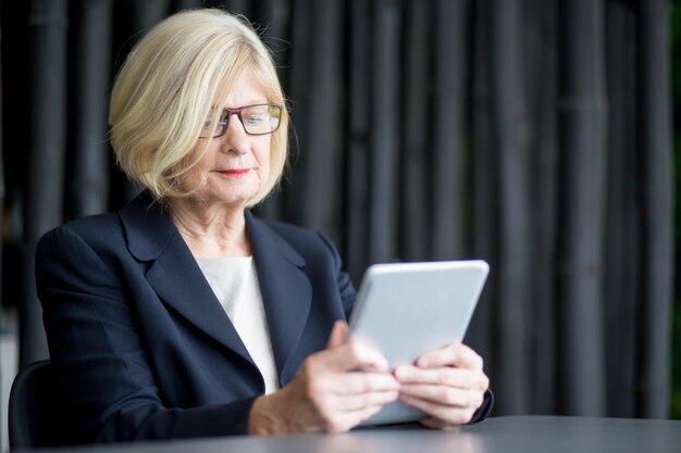 Serious businesswoman using digital tablet
