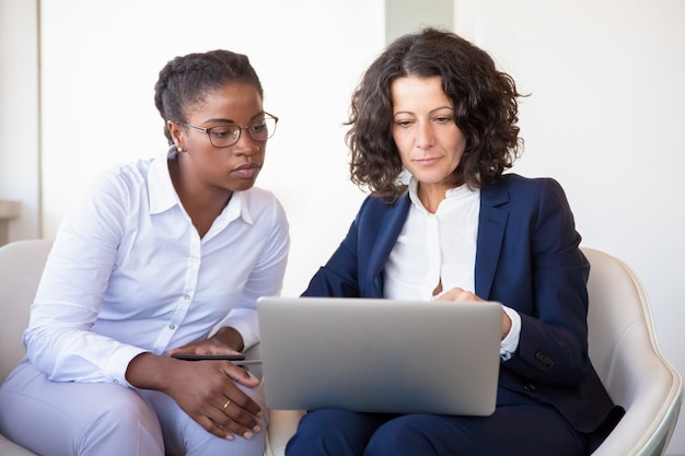 Free photo serious businesswomen watching presentation together