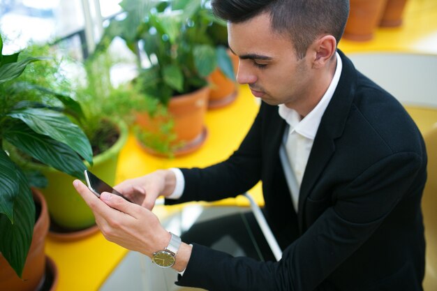 Serious busy businessman using smartphone for work