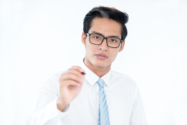 Serious calm Asian businessman drawing on invisible board