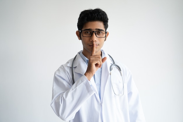 Serious calm Indian doctor keeping information in secret.